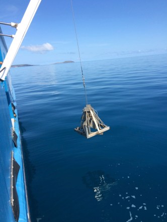 The reflection of the sediment grab instrument is clearly visible in the very calm seas.